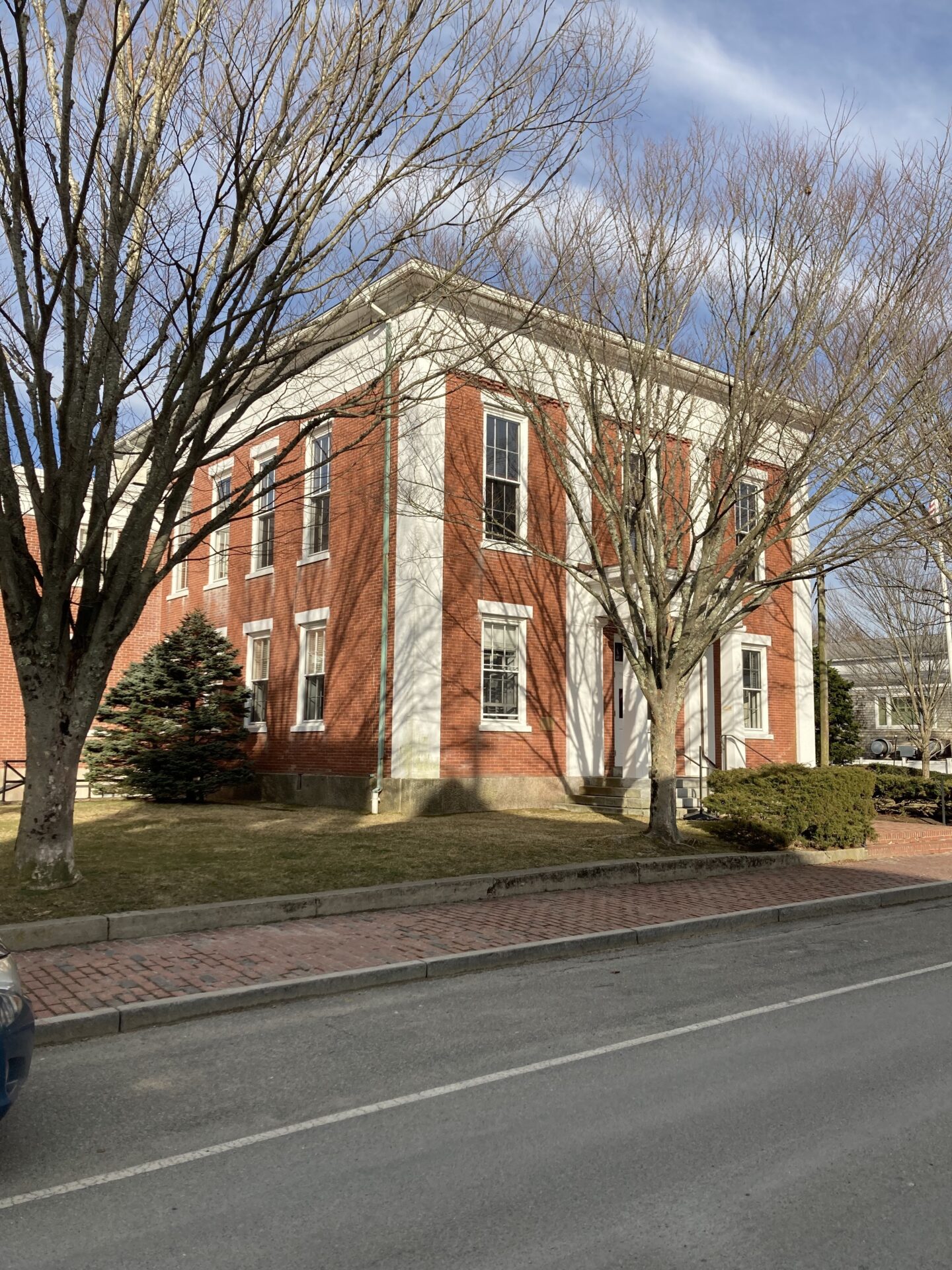 A red brick building with trees in front of it.